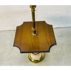 a wooden table with a candle on it and a white wall in the back ground