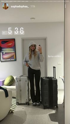 a woman taking a selfie in front of her luggage