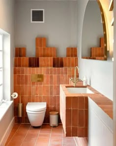 a bathroom with orange tiles on the walls