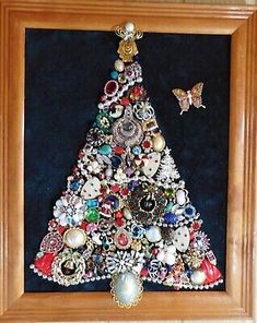 a wooden frame with a christmas tree made out of buttons and other things on it