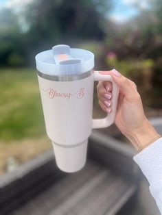 a woman holding a coffee cup in her hand