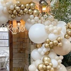 white and gold balloons are hanging from the ceiling