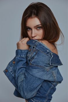 a woman wearing a jean jacket posing for the camera