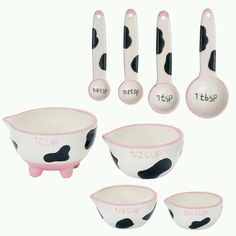 a set of measuring spoons and bowls with cow print