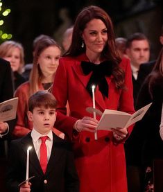 the young boy and woman are holding candles as they stand in front of other people