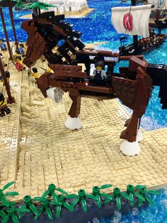 a lego horse that is standing in the water next to some other toy boats and ships