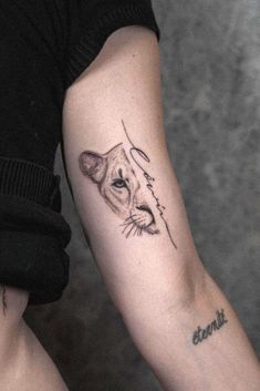 a woman's arm with a small tattoo of a cat