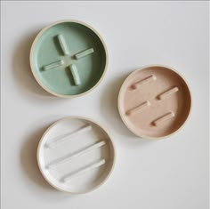 three small plates with different shapes and sizes on top of each other, one has a cross in the middle