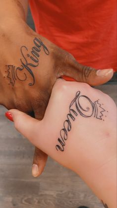 two people holding hands with tattoos on them