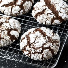 chocolate crinkle cookies cooling on a wire rack with powdered sugar sprinkled on top