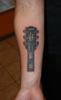 a man with a guitar tattoo on his arm