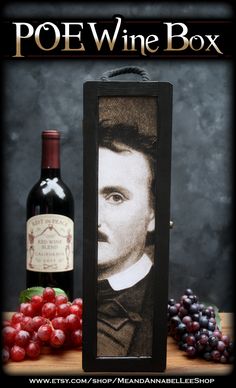 a bottle of wine sitting next to a photo frame with grapes and a bottle of wine in the background