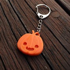 an orange pumpkin shaped keychain on a wooden surface