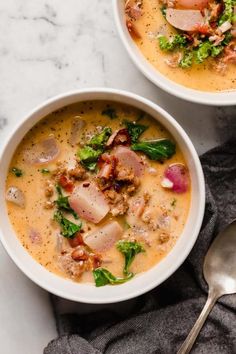 two bowls of soup with ham, broccoli and other toppings on a marble surface