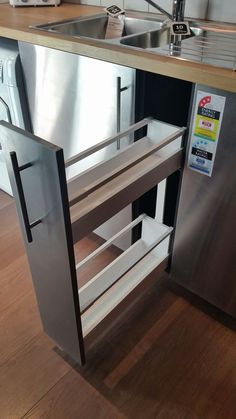 a stainless steel sink and dishwasher in a kitchen with wood flooring on the walls