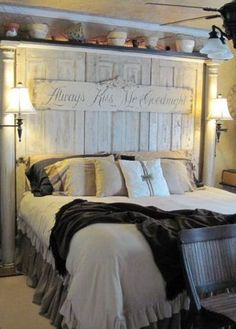 a white bed sitting under a wooden headboard next to two lamps on either side of it