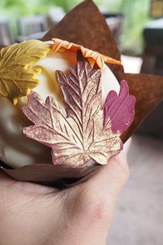 a hand holding an object with leaves on it