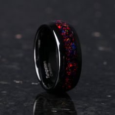 black ceramic ring with red and blue glitter inlays on it's center