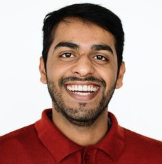 a smiling man in a red shirt is looking at the camera