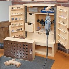 a wooden tool cabinet with tools in it