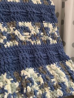 a crocheted blanket sitting on top of a bed