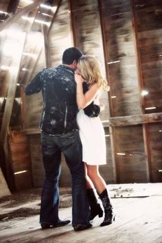 a man and woman embracing in an old barn