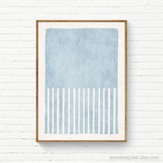 a blue and white painting hanging on a brick wall