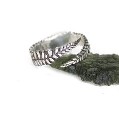 This beautiful sterling silver ring band has a continuous pattern of a fern around the band.   the band is approx 1/8 inches wide and available in multiple sizes.  This ring started as an original wax carving, and was cast in sterling silver.   made with 925 Sterling Silver and oxidized  This fern ring was designed to honor the natural world.  It will match with cottage core and fairy core styles, and will work wonderful by itself as a statement ring.  This is super comfortable to wear, with a continuous pattern of the fern all around the band, not interrupting the flow of the design.   All ages can wear, collect, and appreciate this beautiful ring.  This ring can be custom made in gold.  Either 14k, 18k, or white gold options available upon request.   Please note that the price of a custo White Sterling Silver Nature-inspired Rings, Hand Forged Silver Rings With Nature-inspired Style, Hand Forged Sterling Silver Rings In Nature-inspired Style, Nature-inspired Silver Rings With Natural Inclusions, Green Sterling Silver Nature-inspired Ring, Silver Casting, Wax Carving, Sterling Silver Stacking Rings, Sterling Silver Rings Bands