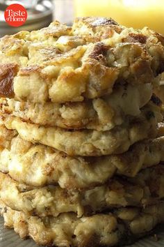 a stack of food sitting on top of a plate next to a glass of orange juice