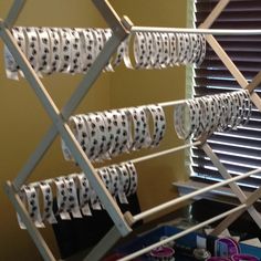 several rolls of toilet paper are hanging on a rack in front of a window with blinds