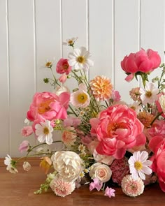 a bunch of flowers sitting on top of a wooden table