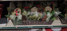 christmas decorations are on display in the store for holiday sales, including pine cones and evergreens