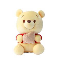 a yellow teddy bear sitting on top of a white floor next to a pink object