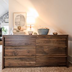 a wooden dresser sitting on top of a carpeted floor