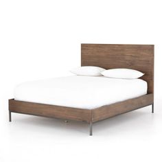 a bed with two pillows on top of it and a wooden frame around the headboard