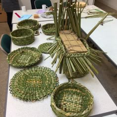 several baskets are arranged on a table with bamboo sticks in the shape of flowers and leaves