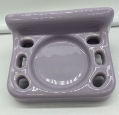 a purple ceramic dish with holes in the middle