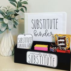 a desk with a sign and some writing on it next to a potted plant