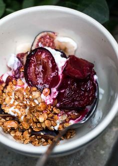 a bowl filled with yogurt, granola and sliced beets on top