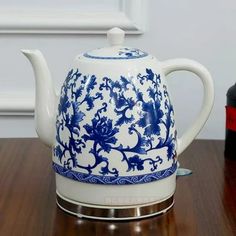 a blue and white tea pot sitting on top of a wooden table