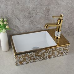 a white sink sitting next to a vase with flowers