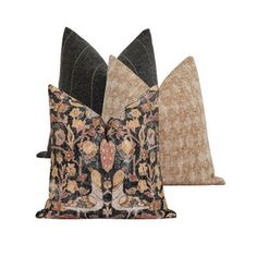 two decorative pillows sitting side by side on top of each other, one in black and the other in brown