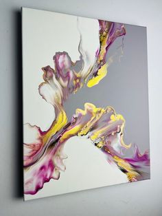 an abstract painting on a white wall with purple and yellow colors in the middle,