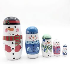 a set of five snowman nesting dolls sitting next to each other on a white surface