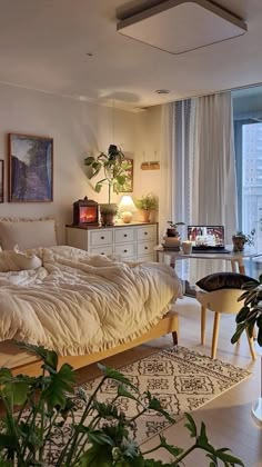 a bed sitting in the middle of a living room next to a potted plant