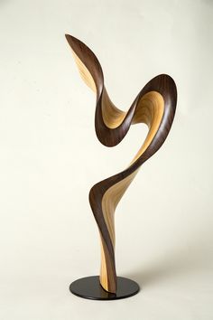 a wooden sculpture is shown on a black stand