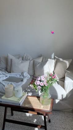 a living room filled with furniture and flowers on top of a coffee table in front of a couch