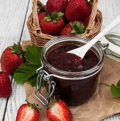 strawberry jam in a jar with strawberries next to it