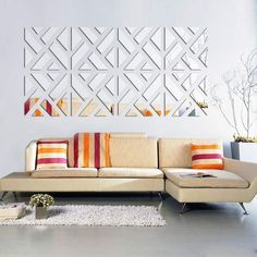 a modern living room with white walls and orange pillows on the couches in front of it