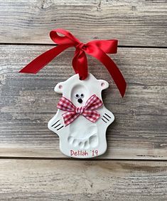 a ceramic bear ornament with a red bow on it's head and name